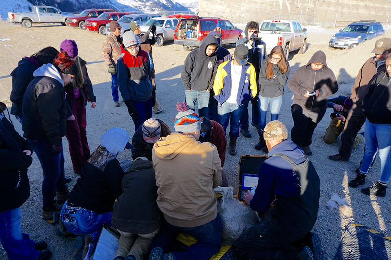 Students watching researchers in a group