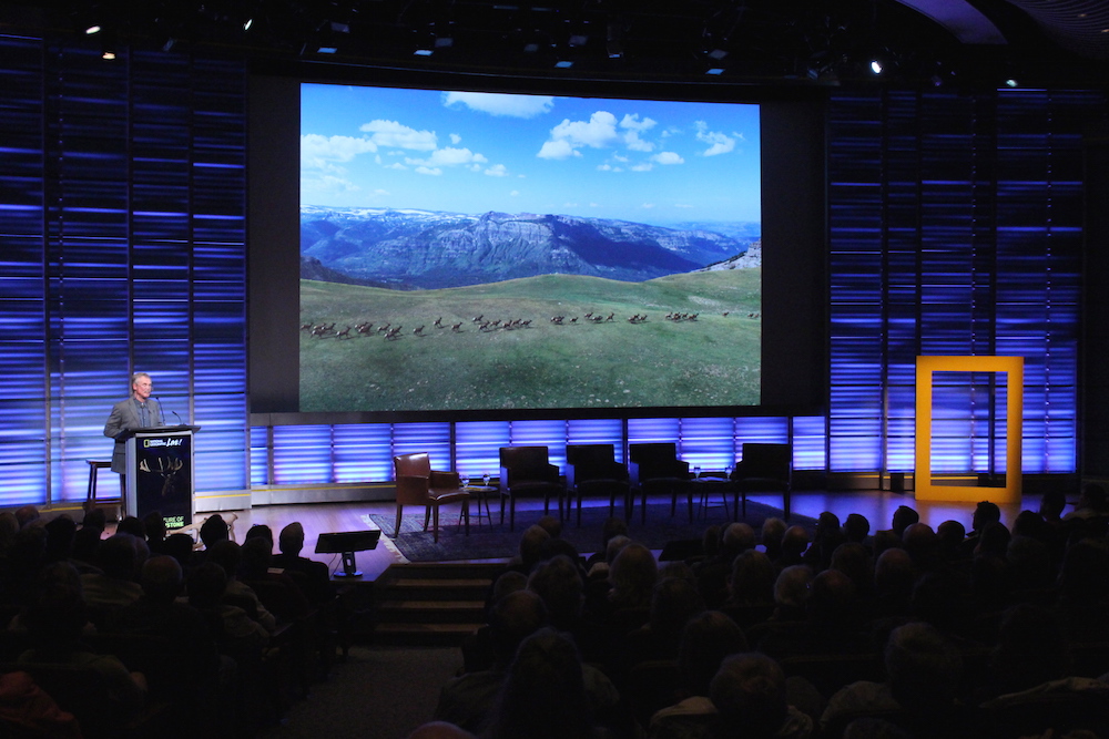 Journalist David Quammen shows a Joe Riis photo of elk on the Thorofare Plateau that appeared in the May 2016 issue of National Geographic.