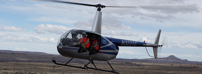 Helicopter hovers over the prairie